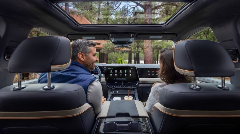 The interior of a GM pickup that shows the infotainment system, with a display in the center console and one for the front-seat passenger.