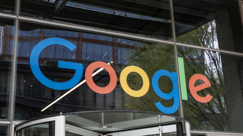 The Google logo on a clear glass office building.