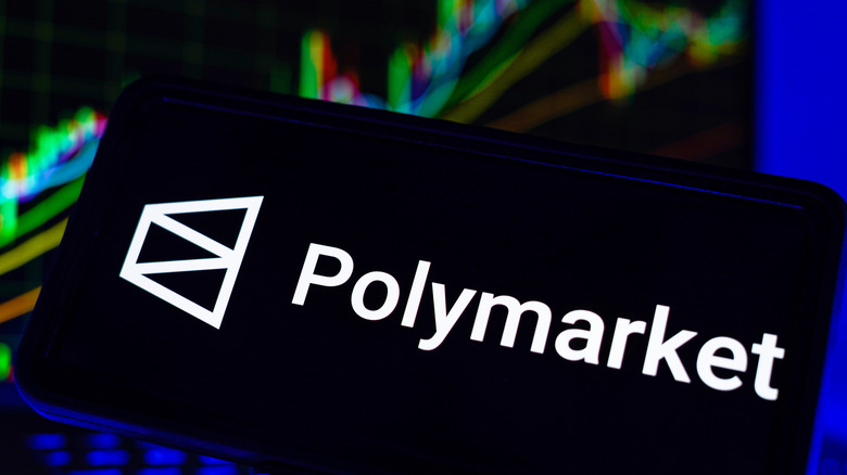 Photo of a smartphone displaying the Polymarket name and logo.