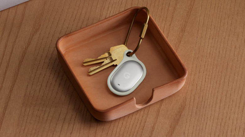 Keys on a dish with a silver location tracker.