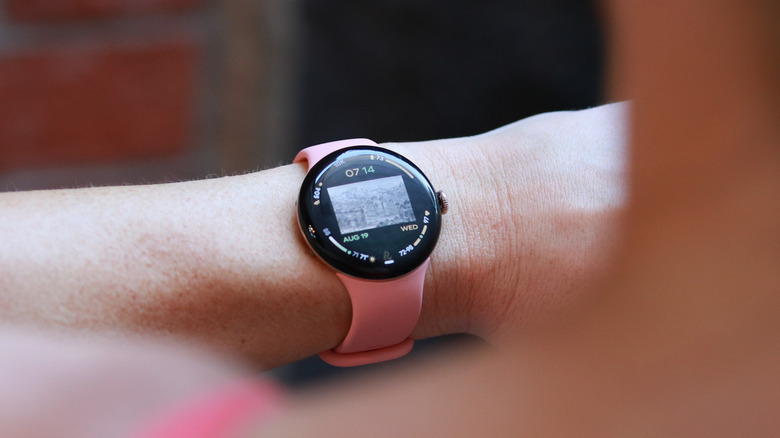 A peach Pixel Watch 5 on a person's wrist.
