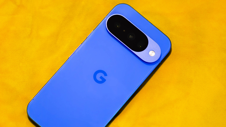 A blue Google Pixel 10 Pro face-down on an orange background.