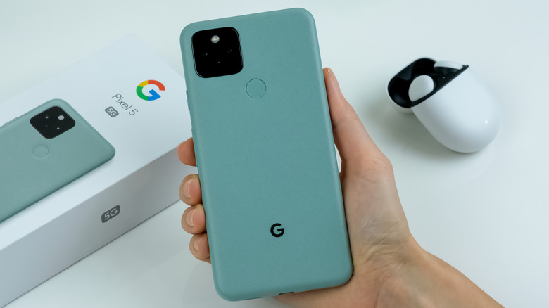 Google Pixel 5 in Sorta Sage color, alongside pixel buds.