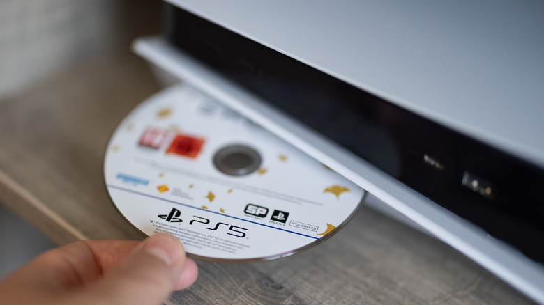 Close-up of a game disc being inserted into a PS5.
