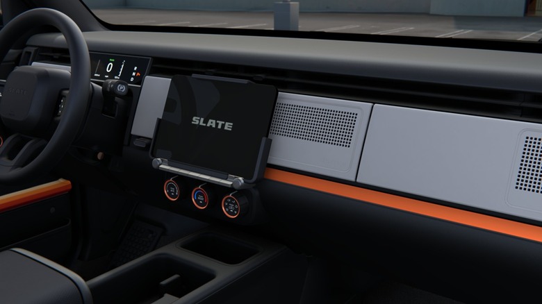 Interior view of a Slate truck. Dark decor with a few orange accents and a mounted tablet.