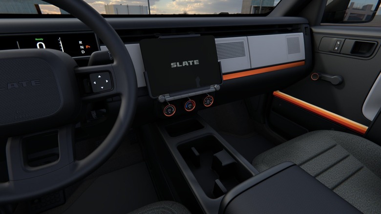 Interior view of a Slate truck. Dark decor with a few orange accents.
