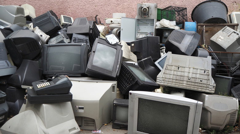 A pile of CRT monitors and other old tech thrown out