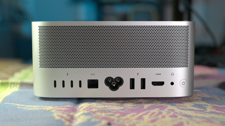 The back of the new Mac Studio M5 Ultra computer with a blue and pink background.