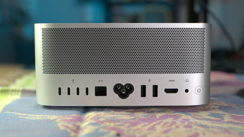 The back of the new Mac Studio M5 Ultra computer with a blue and pink background.