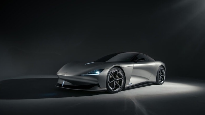 A mockup of a slick, silver Karma Kaveya EV shining in a dark room.