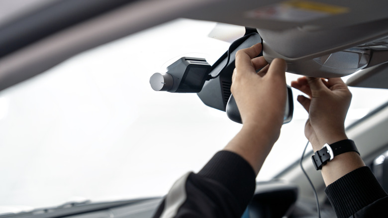 A person installs an in-car camera