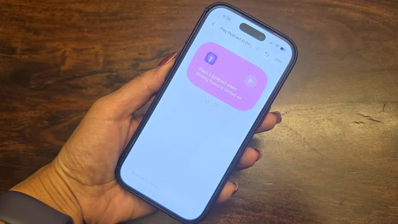 A hand holding an iPhone, showing Driving focus mode with an automation.