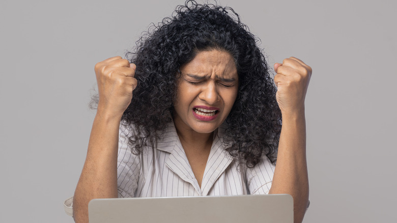 Frustrated woman sitting in front of a laptop.
