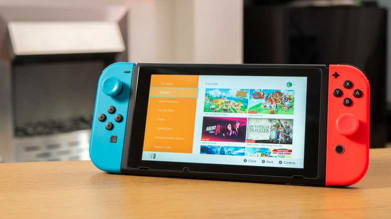 Original Nintendo Switch with blue and red Joy-Con controllers displaying the Nintendo eShop.