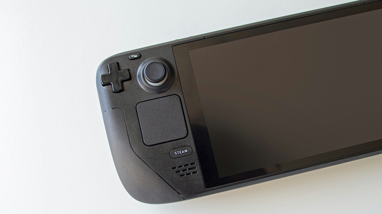 A Steam Deck, with its screen off, on a white surface.