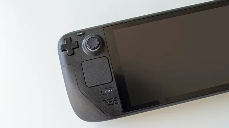 A Steam Deck, with its screen off, on a white surface.