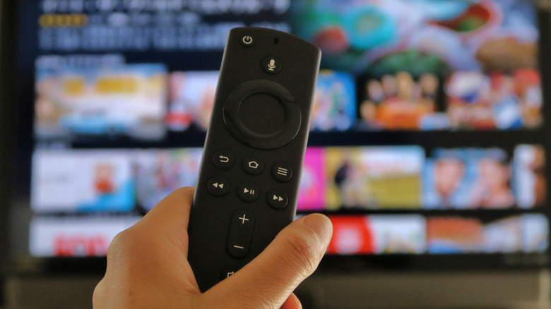 A person holding an Amazon Fire TV Stick remote.