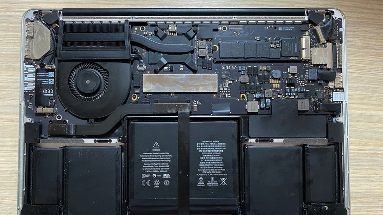 A MacBook with its bottom cover off, showing the internal components