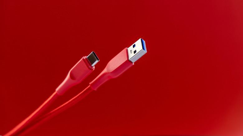 Red USB-A and USB-C cables on red background.