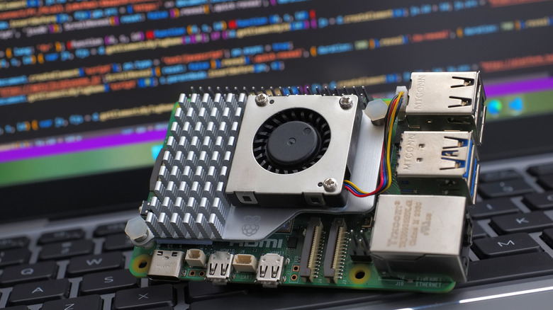 Raspberry Pi 5 set against a laptop with code on-screen.