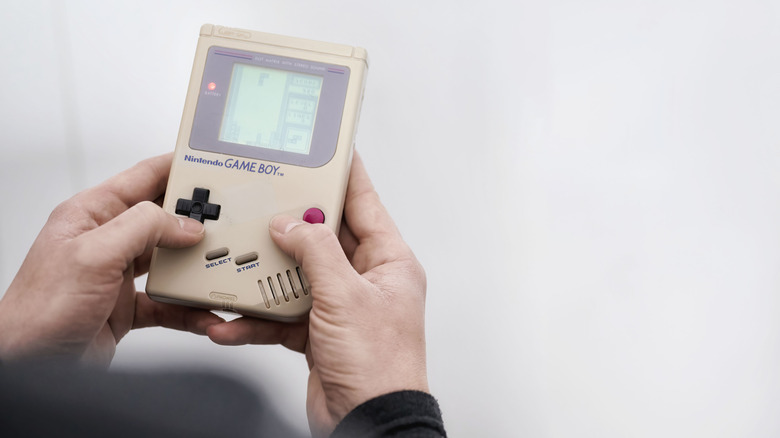 Someone playing Tetris on a Game Boy.