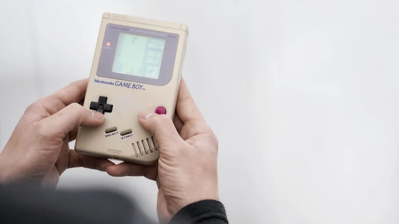 Someone playing Tetris on a Game Boy.