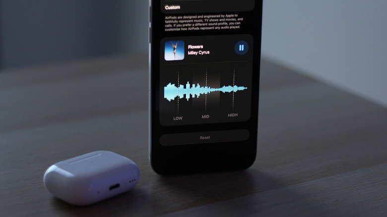 AirPods case next to an iPhone with EQ settings.