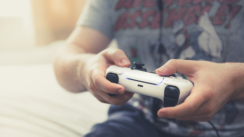 A player's hands holding a PS5 controller