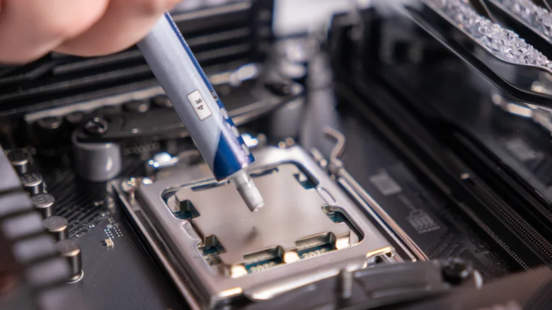 Image of someone applying thermal paste to the CPU.