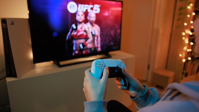 A gamer playing UFC5 on a PS5