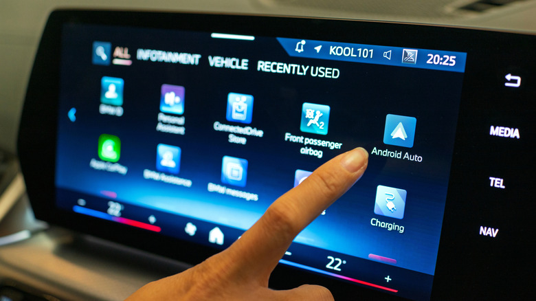 Person choosing Android Auto app on their car's infotainment screen.