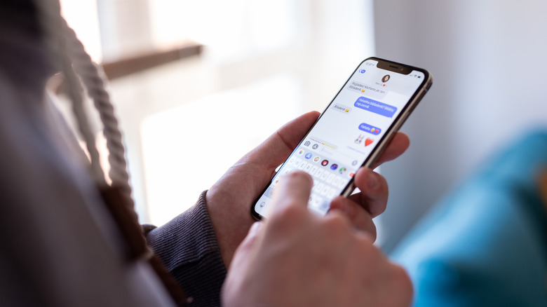Algu&eacute;m conversando no iMessage usando um iPhone.