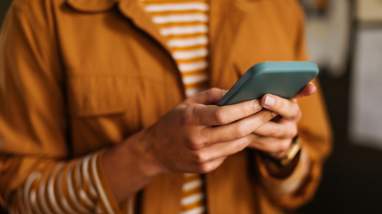 A person typing on a smartphone.