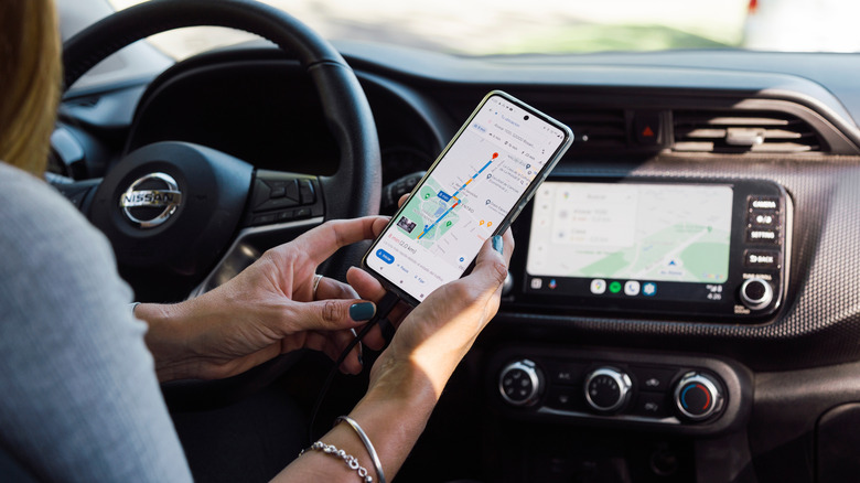 A woman using Android Auto via USB on the car's infotainment system.
