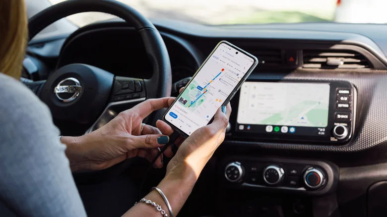 A woman using Android Auto via USB on the car's infotainment system.