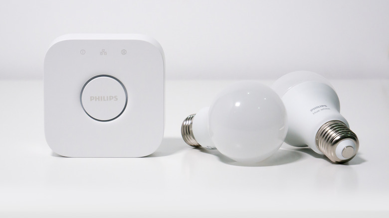 A Philips Hue Bridge with a pair of Hue White smart bulbs.