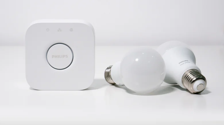 A Philips Hue Bridge with a pair of Hue White smart bulbs.