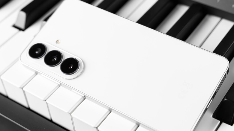 Samsung phone sitting on piano keys.