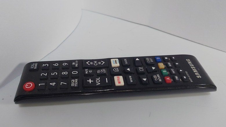A Samsung remote on a plush white couch.