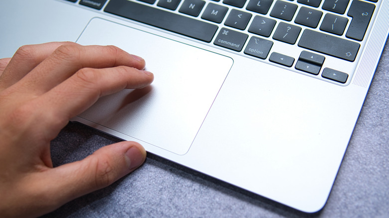 A hand on a MacBook Air trackpad.