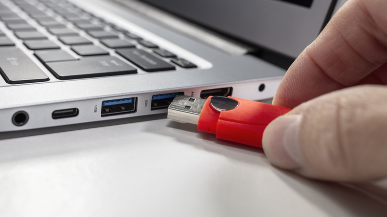 A USB stick being plugged into a laptop