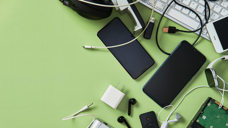 A bunch of cables and gadgets on a green background.