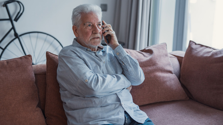Worried elderly man making a phone call