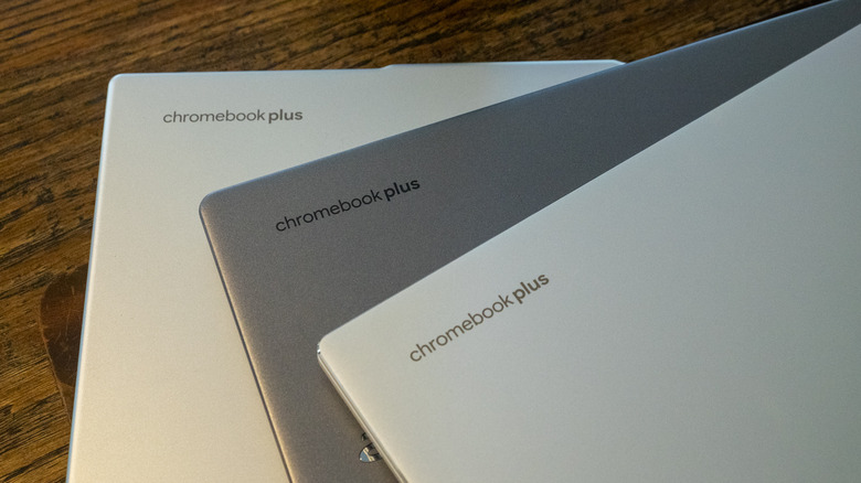 The back of three closed laptops with Chromebook Plus logos in the corners