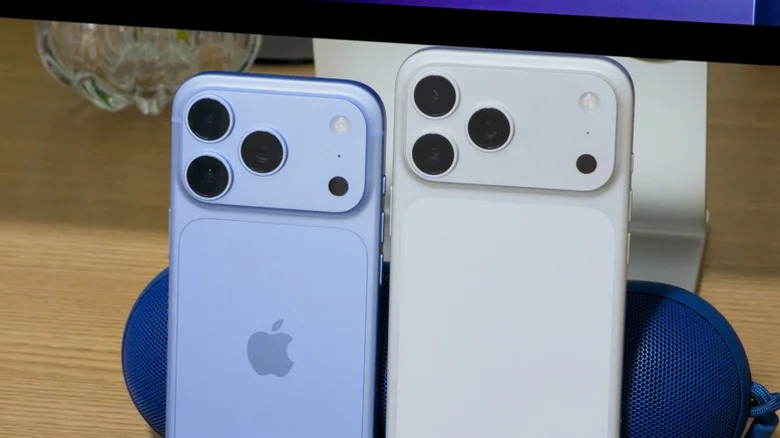 Two iPhone Pro models next to each other: one in blue, one in white.