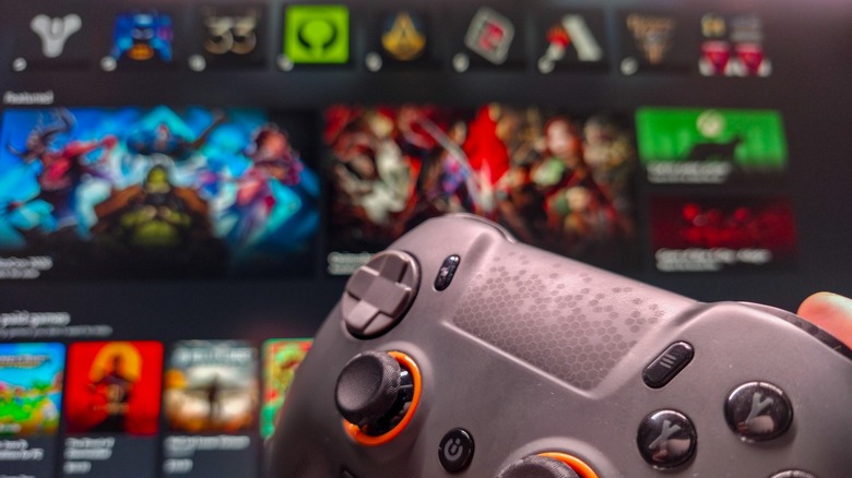 Scuf PC gaming controller with Windows 11 Xbox app in the background.