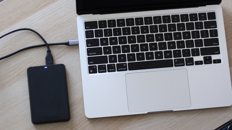 An external hard drive connected to a MacBook.