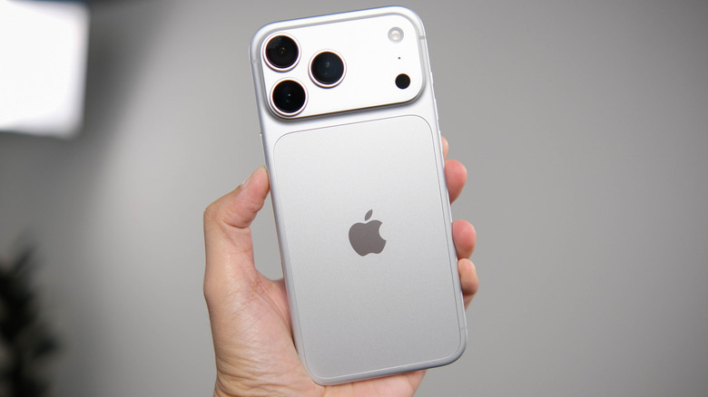 The back of a silver iPhone 18 Pro held aloft.