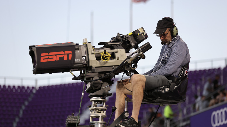 A man working an ESPN television camera.