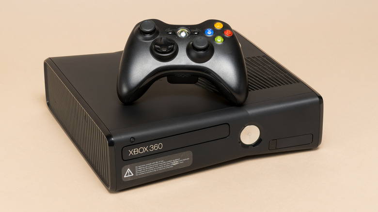 An Xbox 360 console with a controller on top